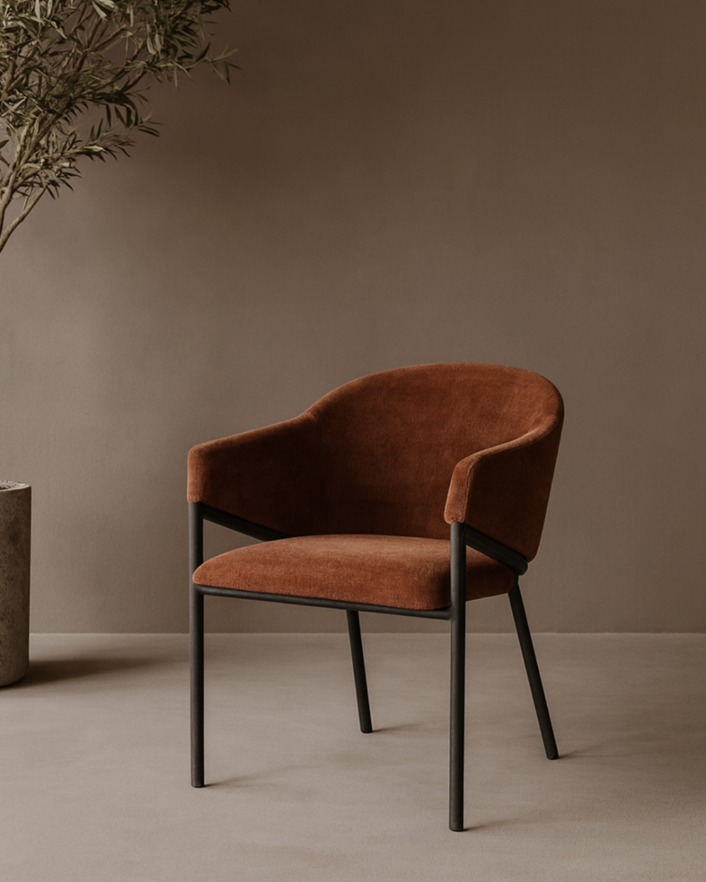 Tommy Franks Rust Brown armchair against a plain wall with a plant on the left