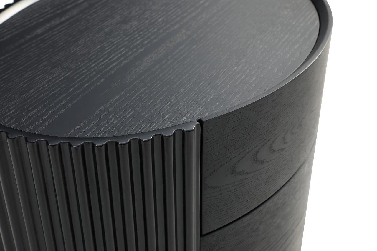 Close-up of a cylindrical Black Latine Bedside table with a ribbed texture.