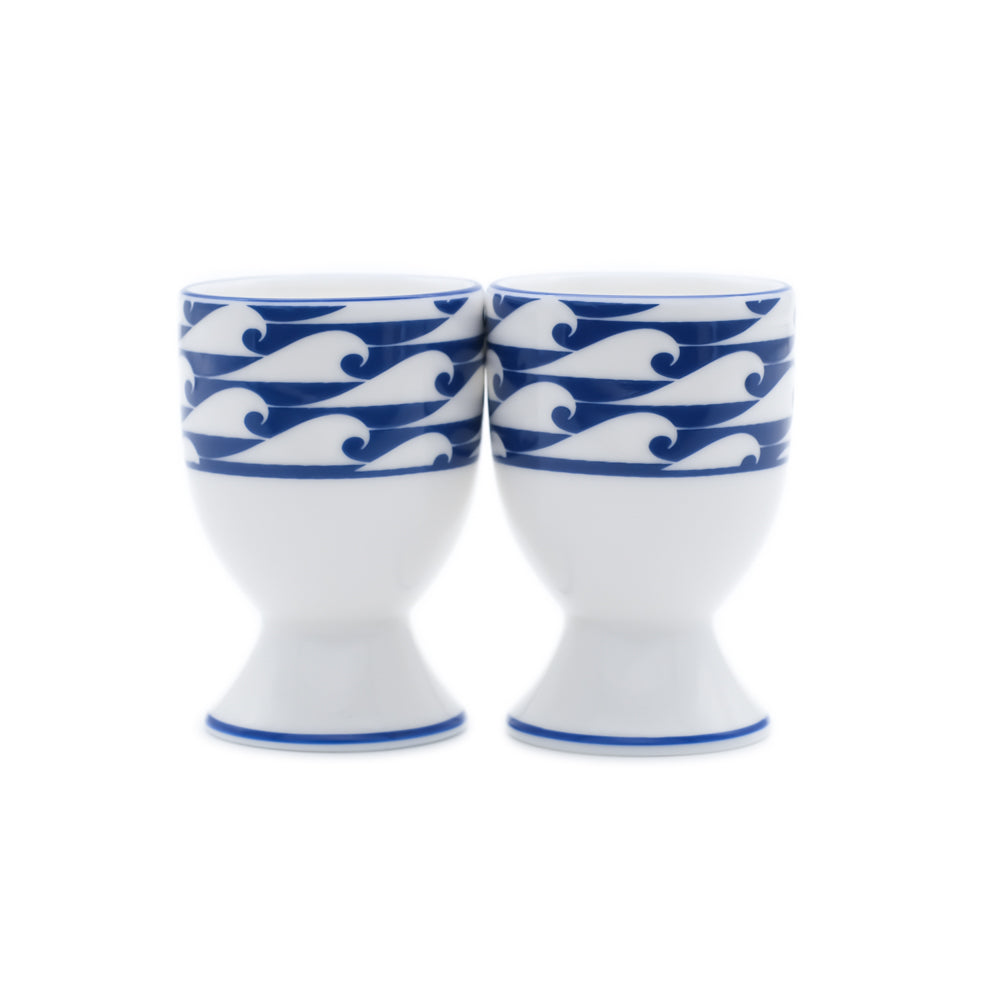 Two white egg cups with blue wave patterns on a white background
