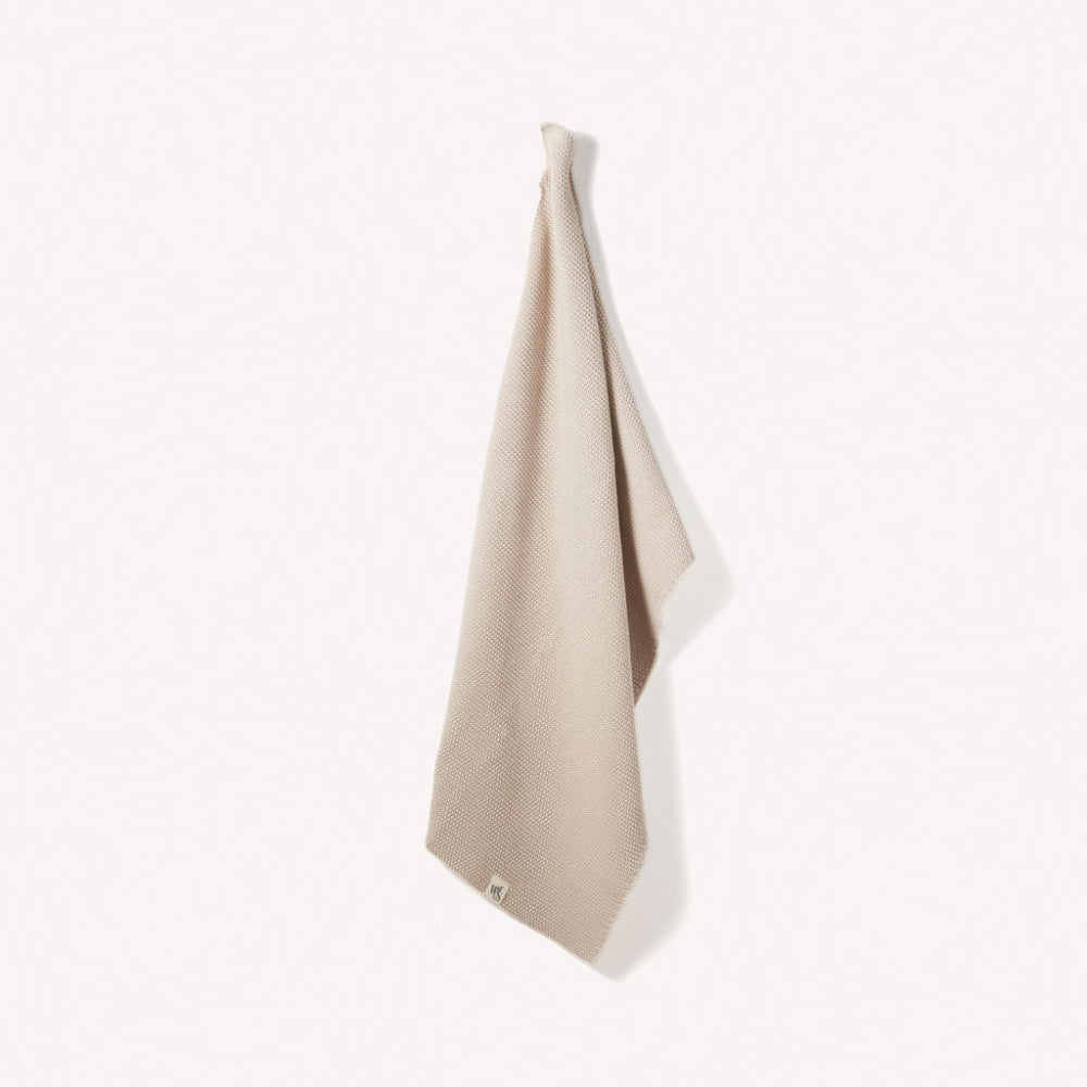 Beach Sand coloured organic hand towel with white border on a light grey background
