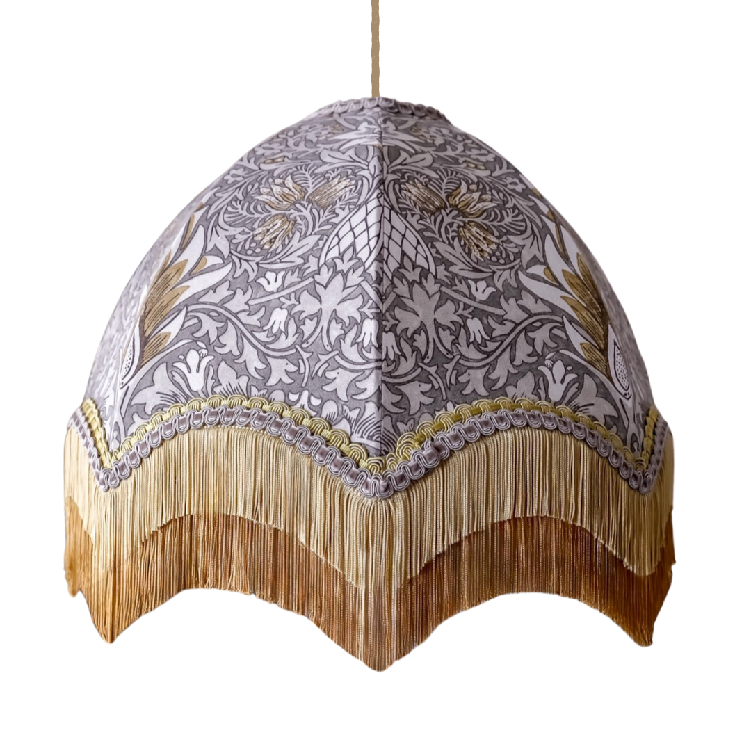 Decorative lampshade with intricate patterns and fringes on a white background
