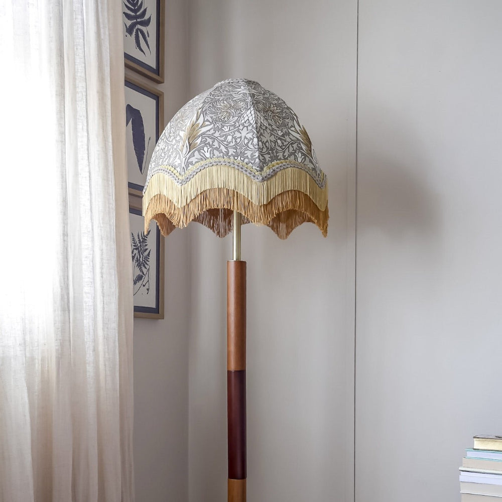 Decorative standing lamp with a patterned shade in a room setting.