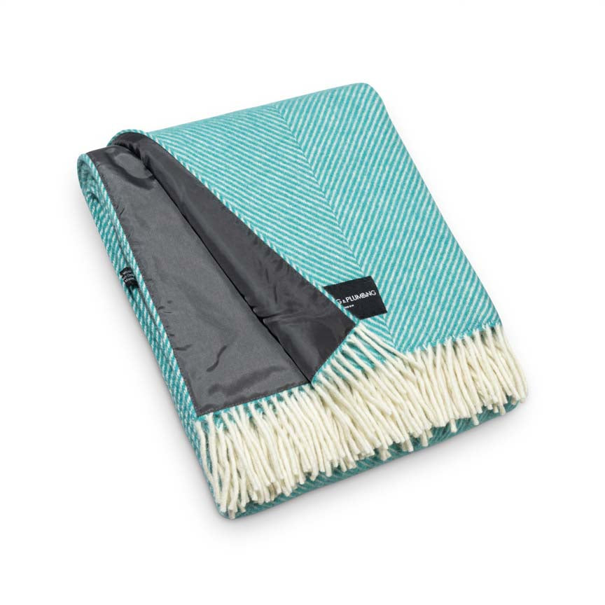 Teal and grey herringbone blanket with white fringe on a white background