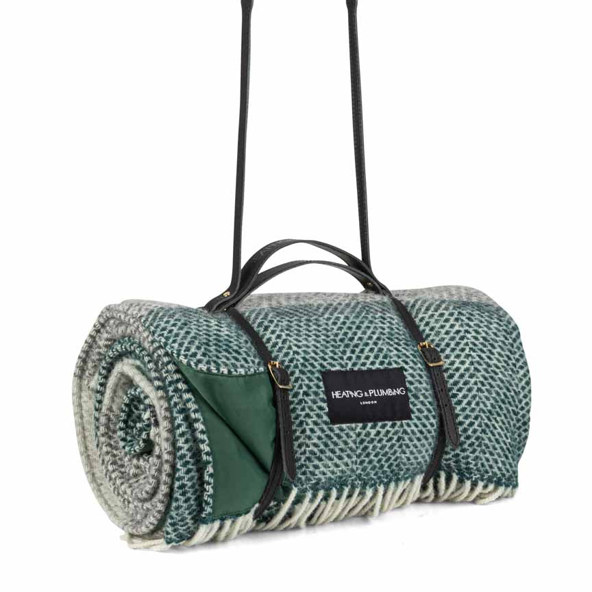 Roll-up picnic blanket with carrying strap on a white background