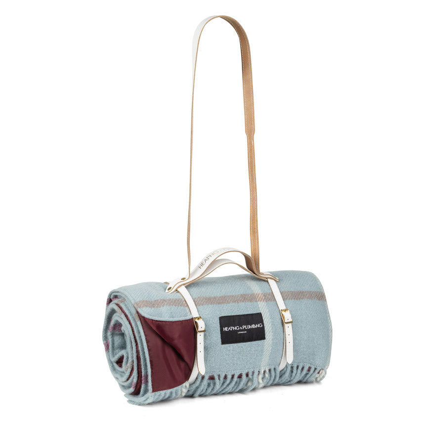 Roll-up picnic blanket with carrying strap on a white background