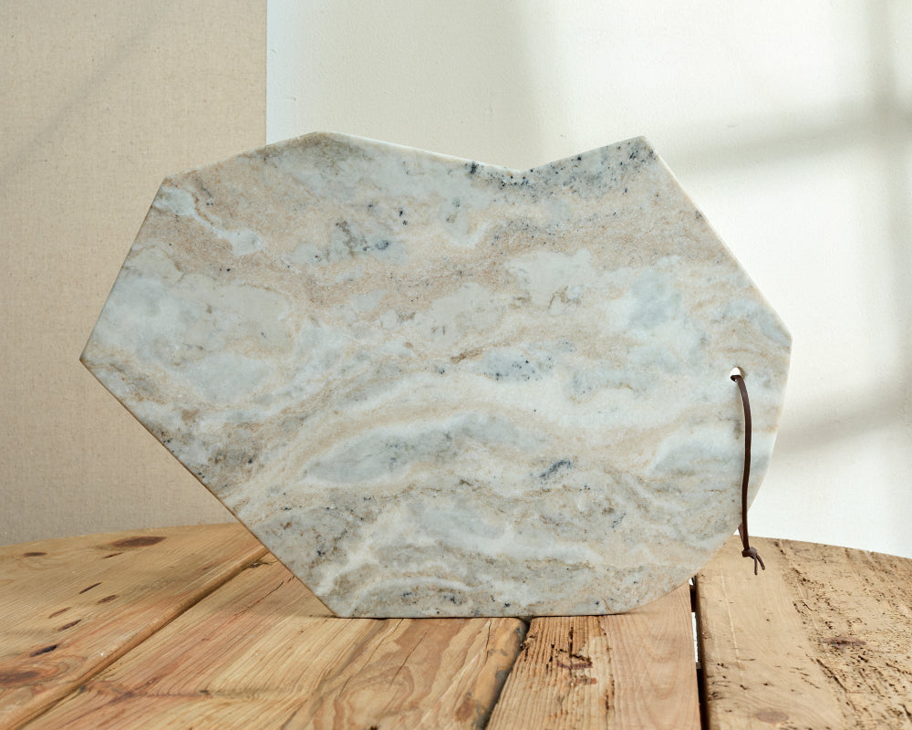Hexagonal marble slab on a wooden surface with a neutral background