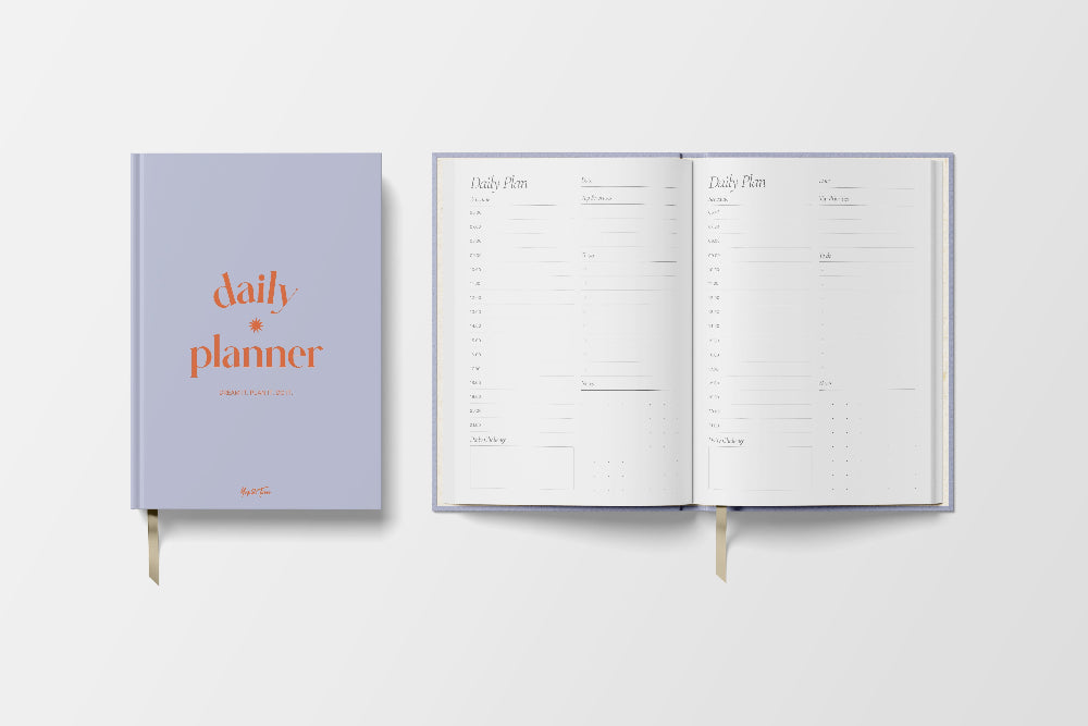 Daily planner book with a purple cover and white pages on a light grey background