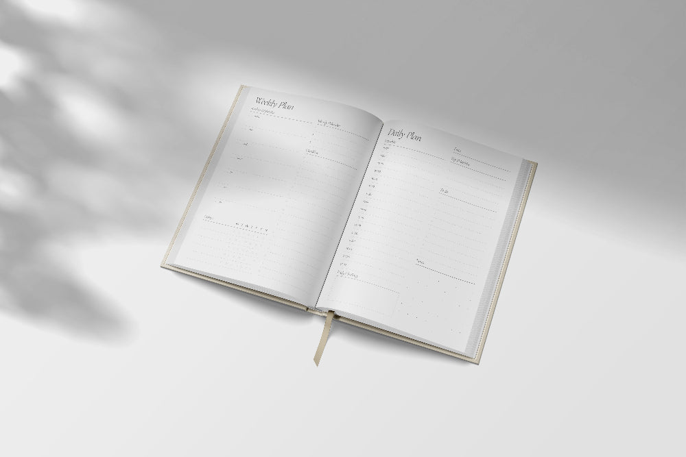 Open planner on a light grey background with soft shadows