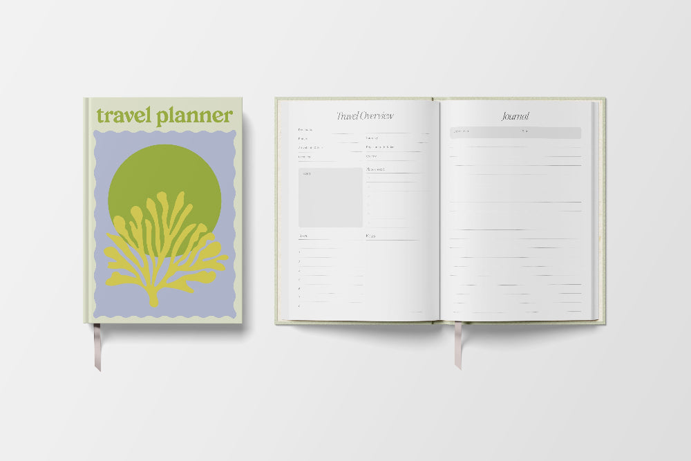 Travel planner book with coral design on cover and open to a journal page.
