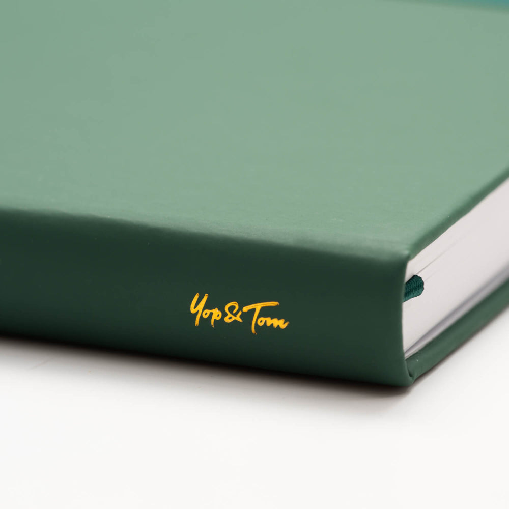 Green notebook with 'Yop&Tom' branding down the Spine on a white background