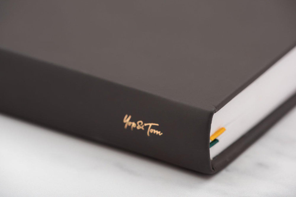 Dark black book with gold embossed text on a marble surface