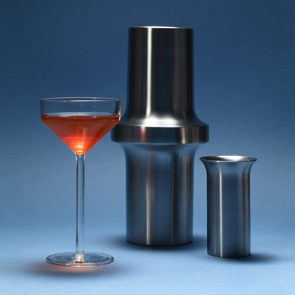 Brushed BARBICAN stainless steel cocktail shaker with matching jigger and a red cocktail