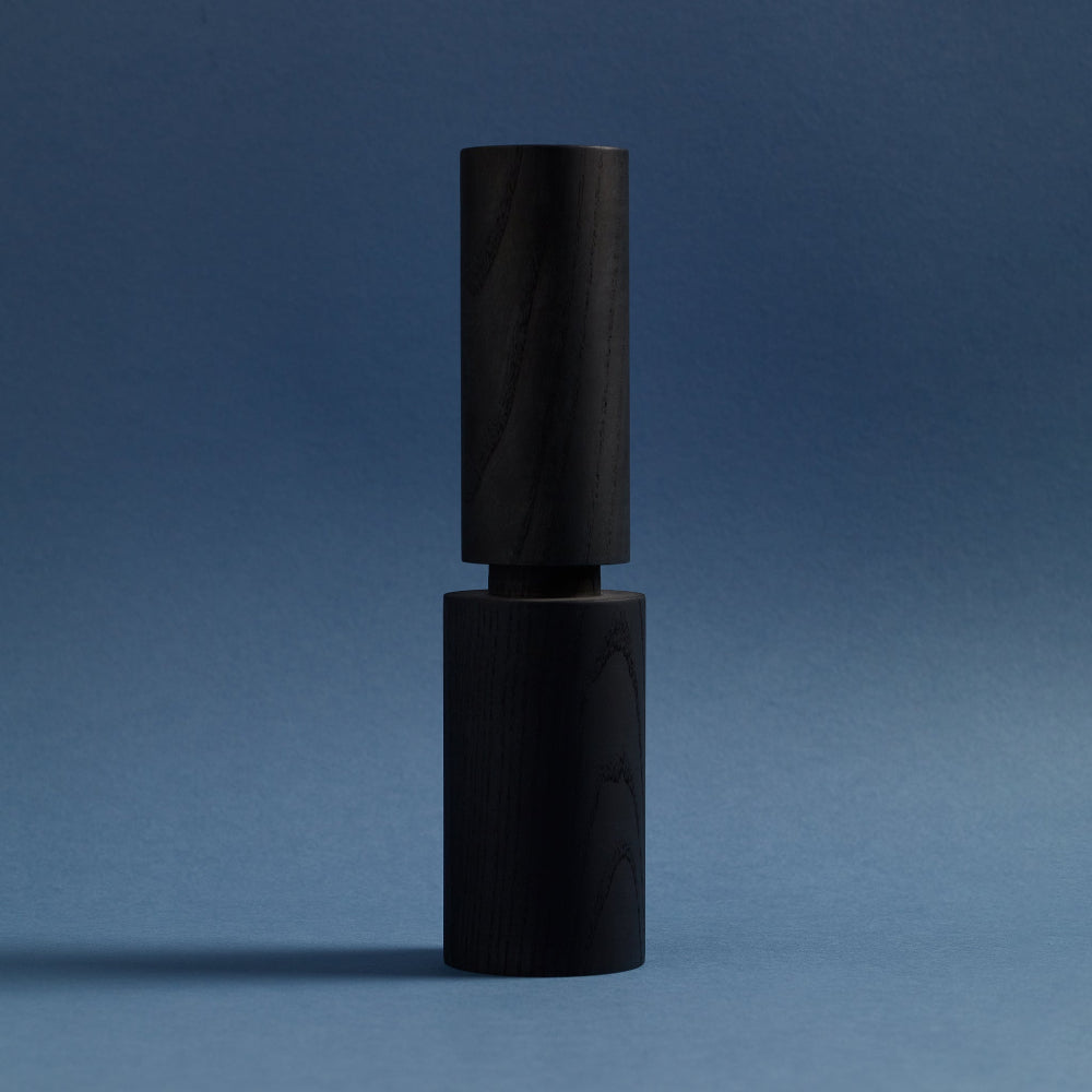 Black salt and pepper mill on a blue background