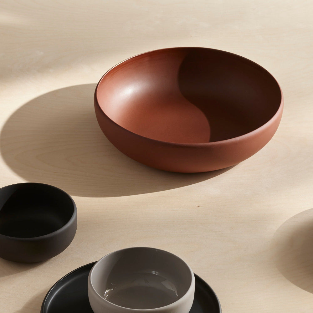 Aaron Probyn COLOMBO large Terracotta porcelain serving bowl on a light wooden surface with coordinating tableware