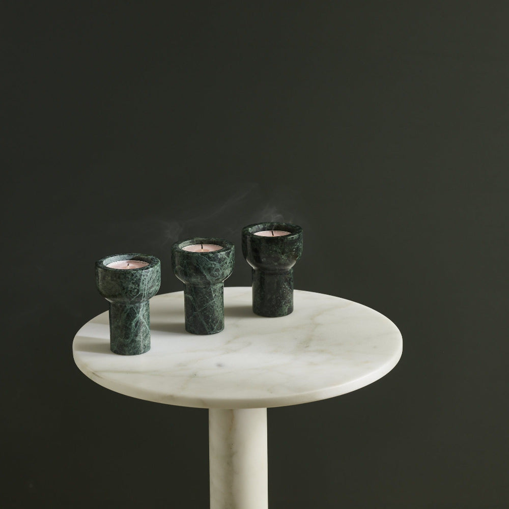 Three Forest Green COMO marble candle holders by Aaron Probyn holding tealights on a round marble table