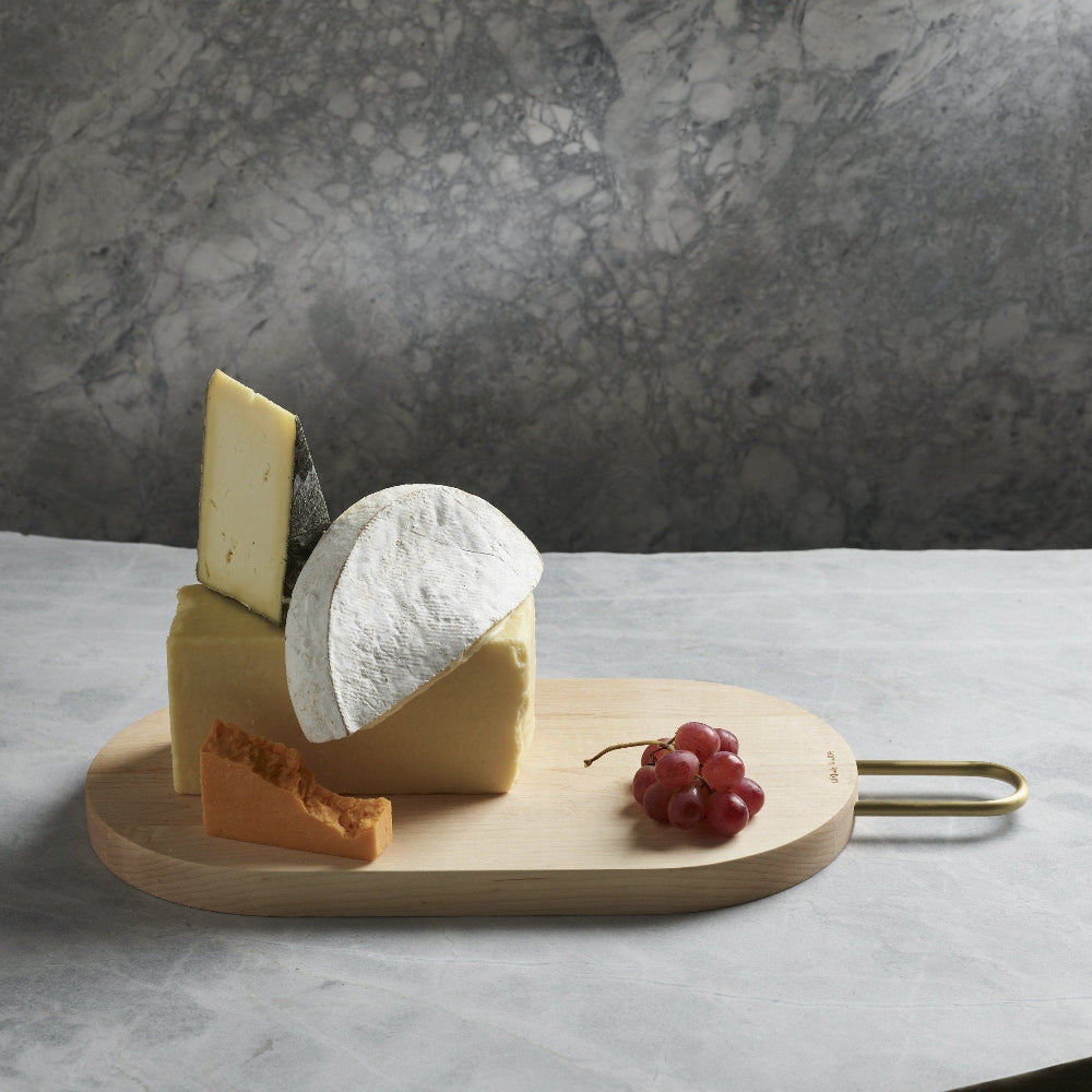 Aaron Probyn HEATH maple wood serving board with assorted cheeses and red grapes on a stone surface