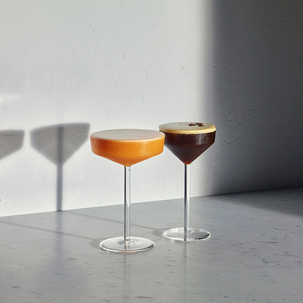 Pair of JUNIPER stemmed cocktail glasses by Aaron Probyn filled with contrasting cocktails