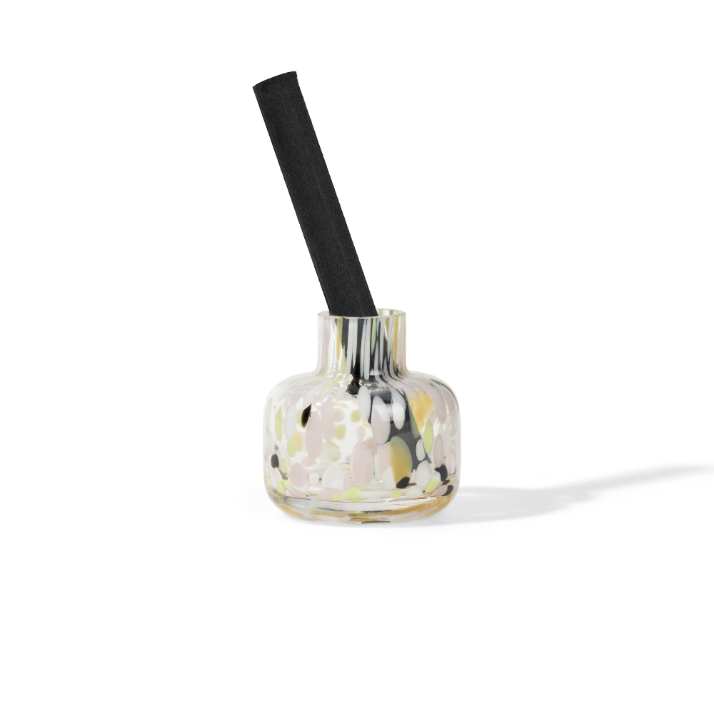 Clear glass bottle with reed diffuser sticks on a white background