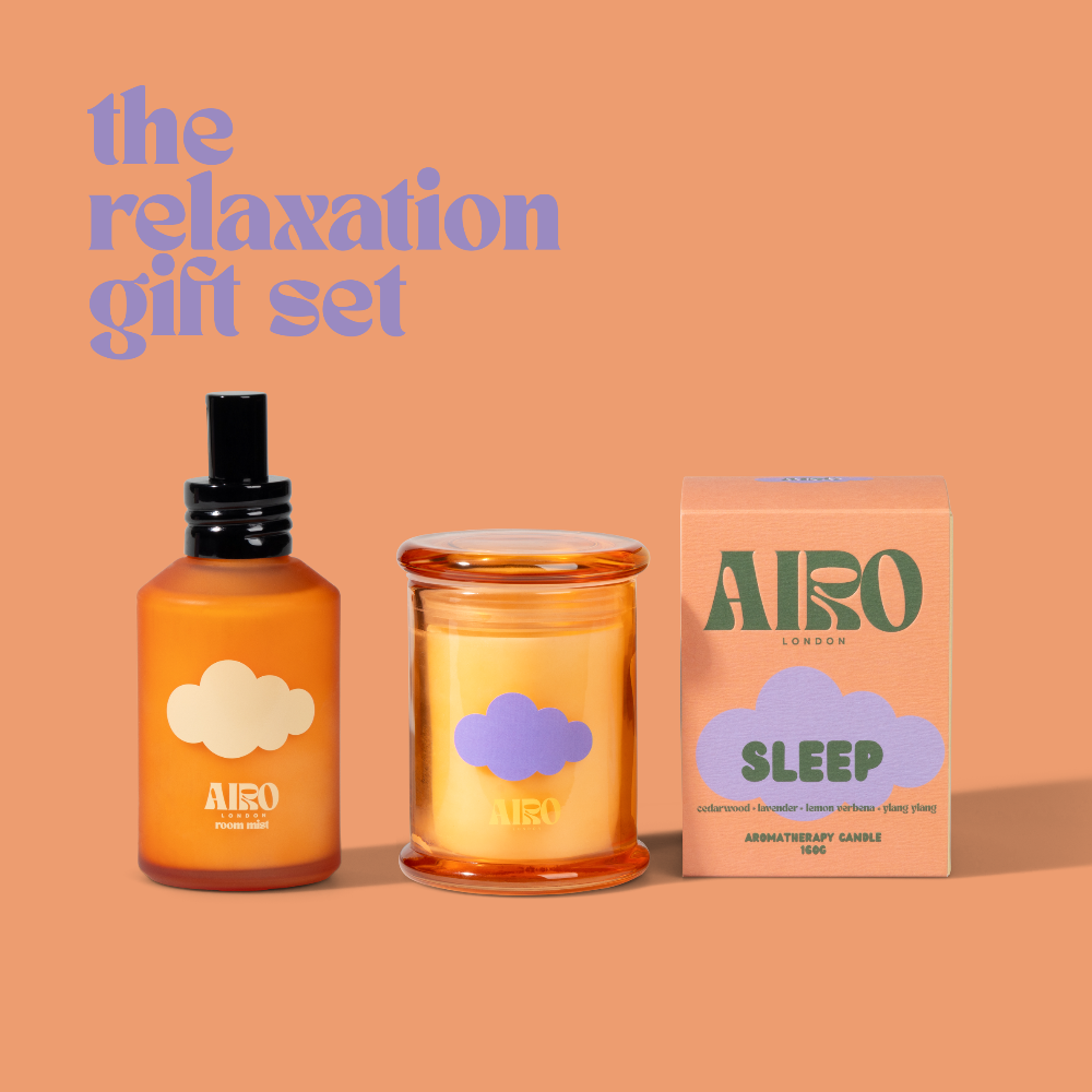 Airo relaxation gift set with bottle, candle, and packaging on a peach background