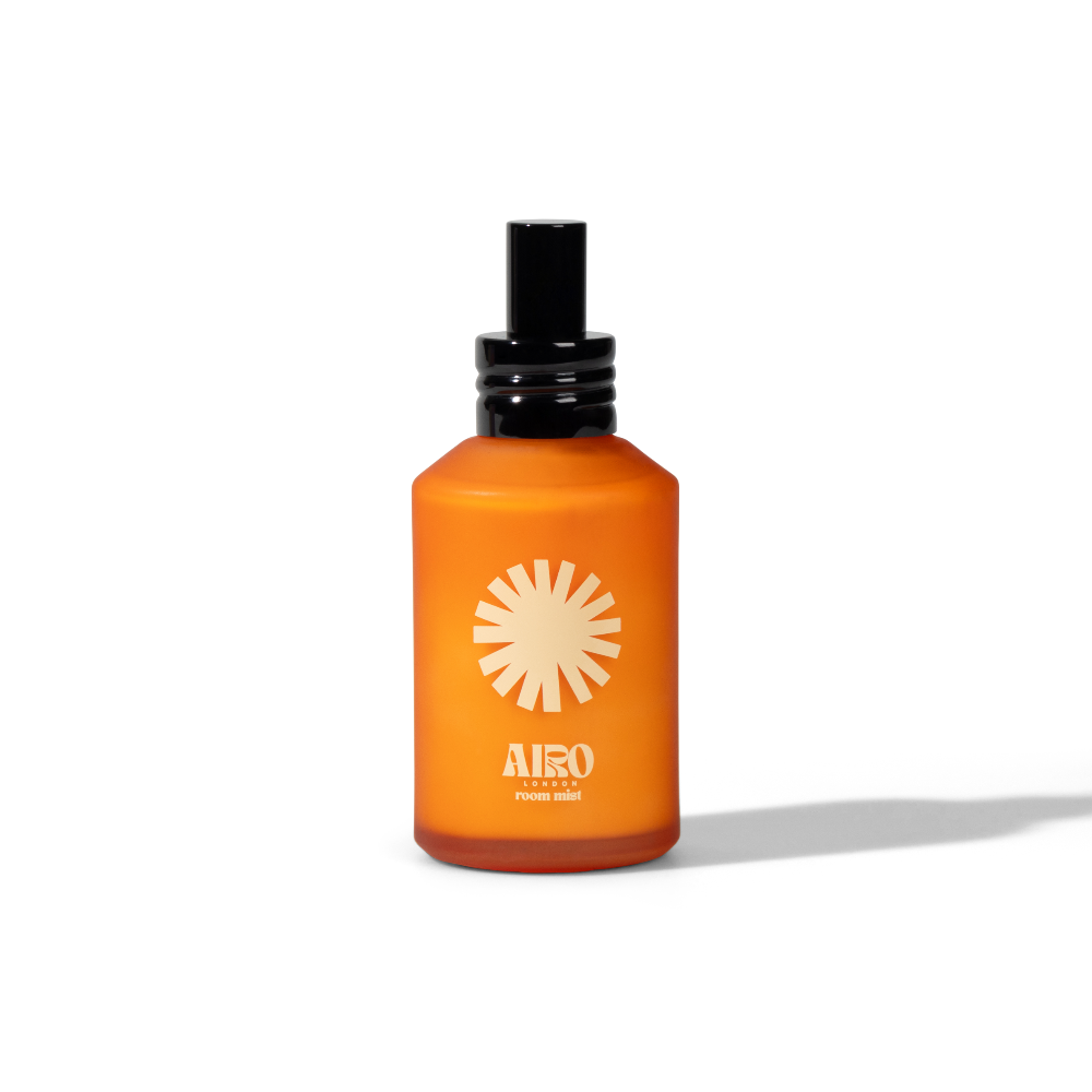 Orange bottle with black cap on a white background labelled airo room mist