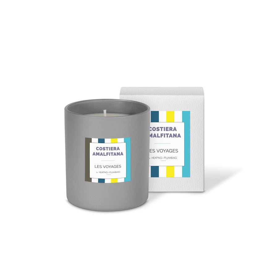 Grey candle with Costiera Amalfitana label next to its packaging on a white background