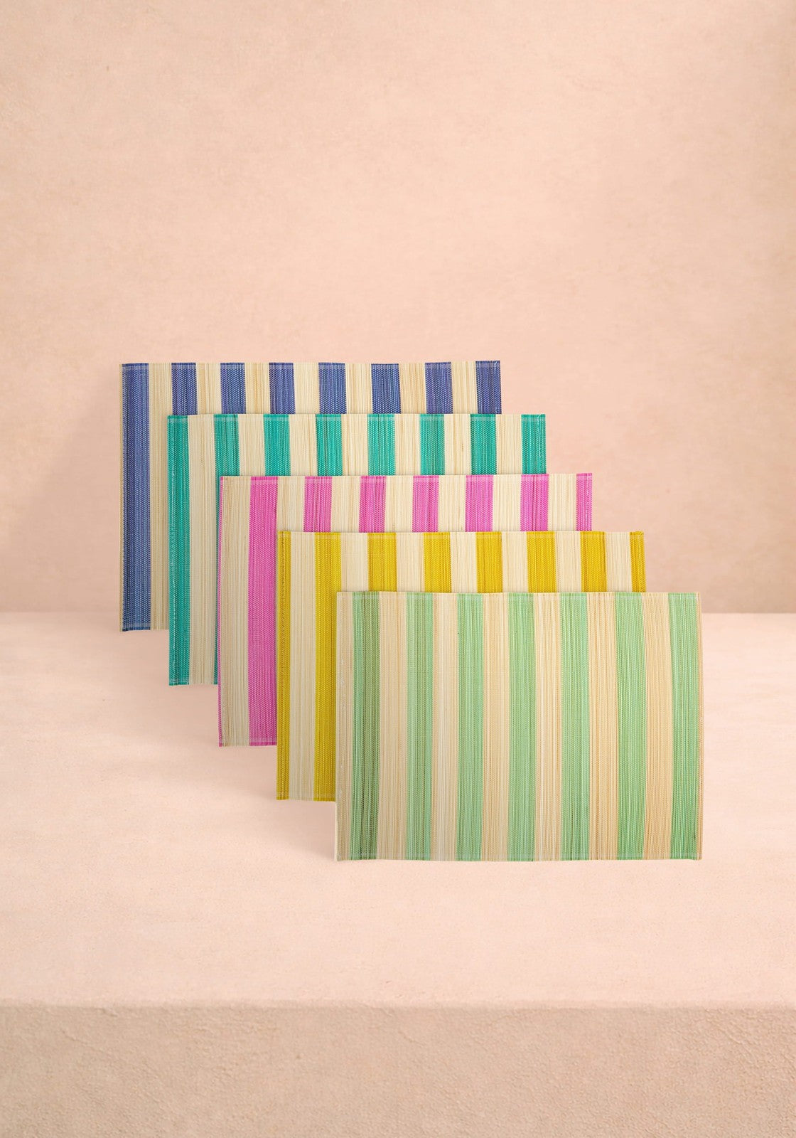 Set of colourful striped table placemats on a beige background