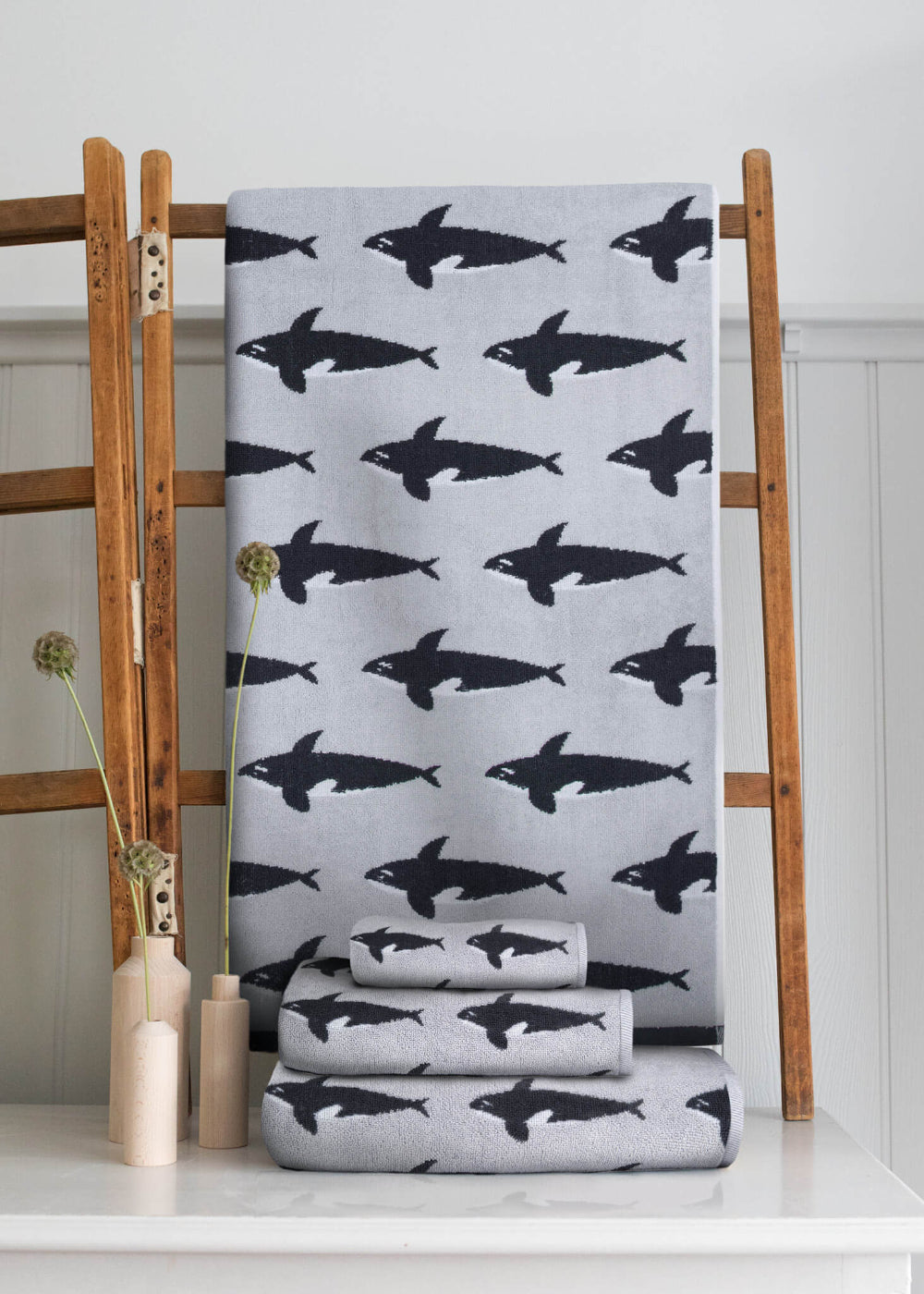 Grey towel with Orca Whale pattern on a wooden rack