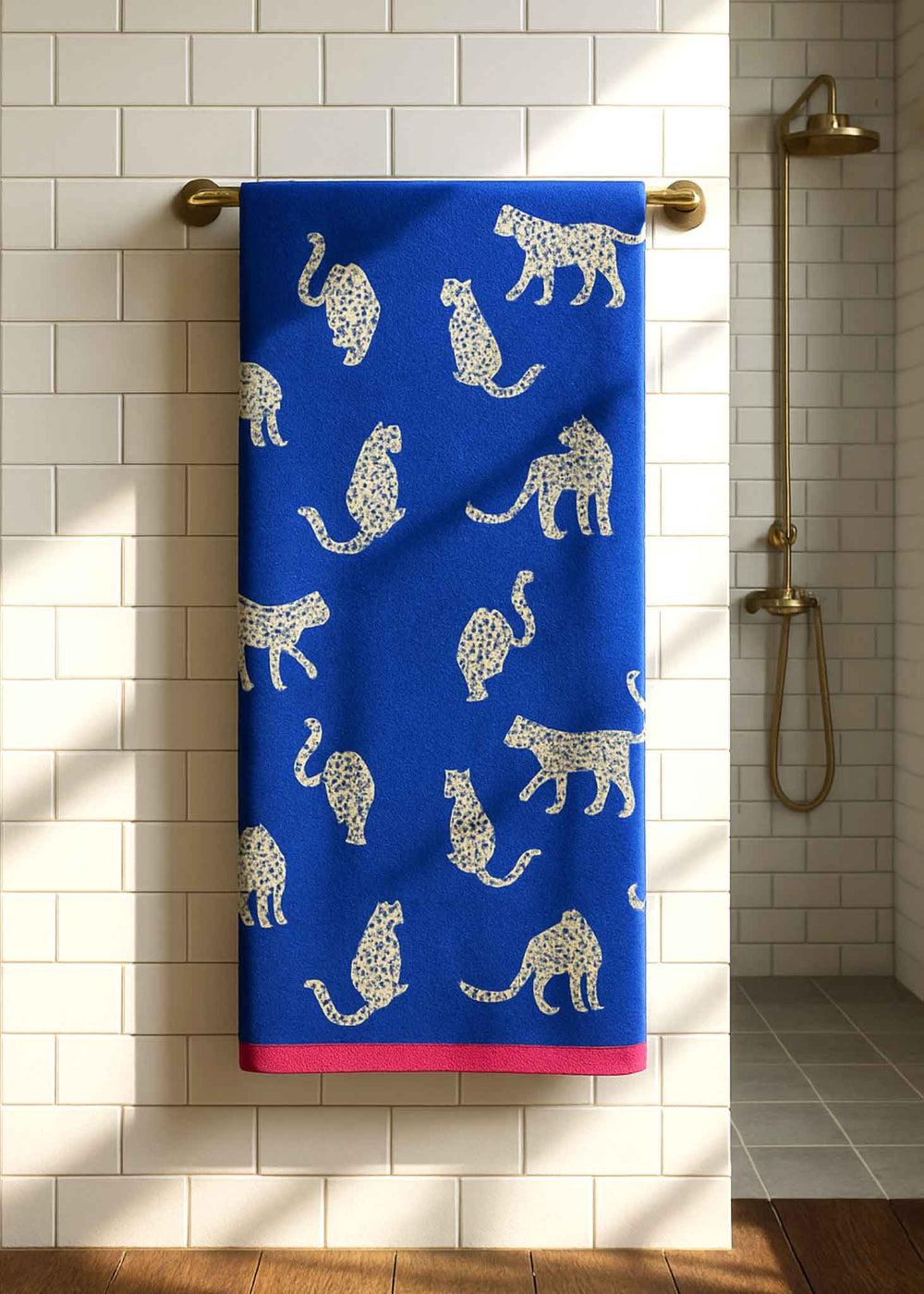 Blue towel with white animal pattern hanging on a towel rack in a bathroom.
