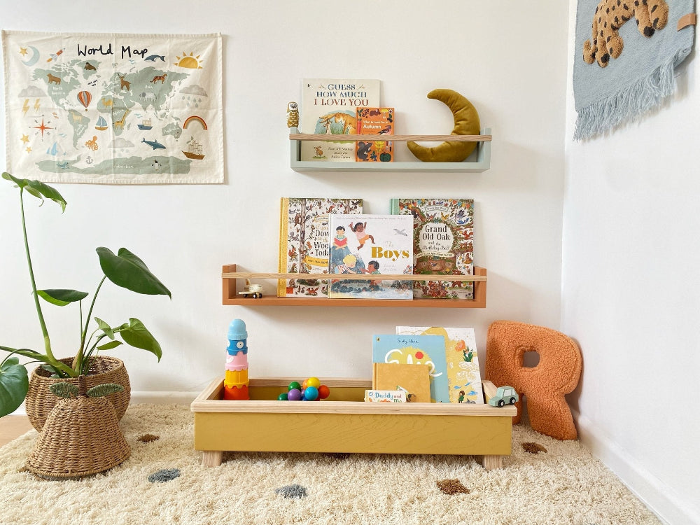 Children's room with shelves, books, and toys on a carpeted floor.