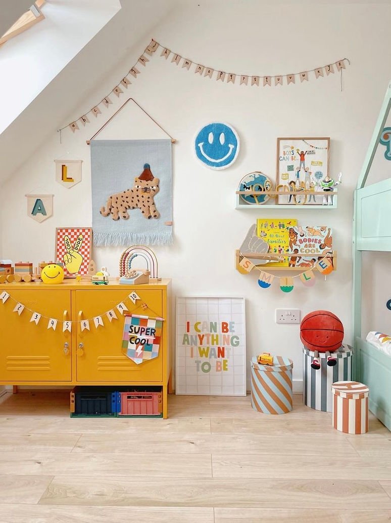 Children's room with colorful furniture, toys, and wall decorations.