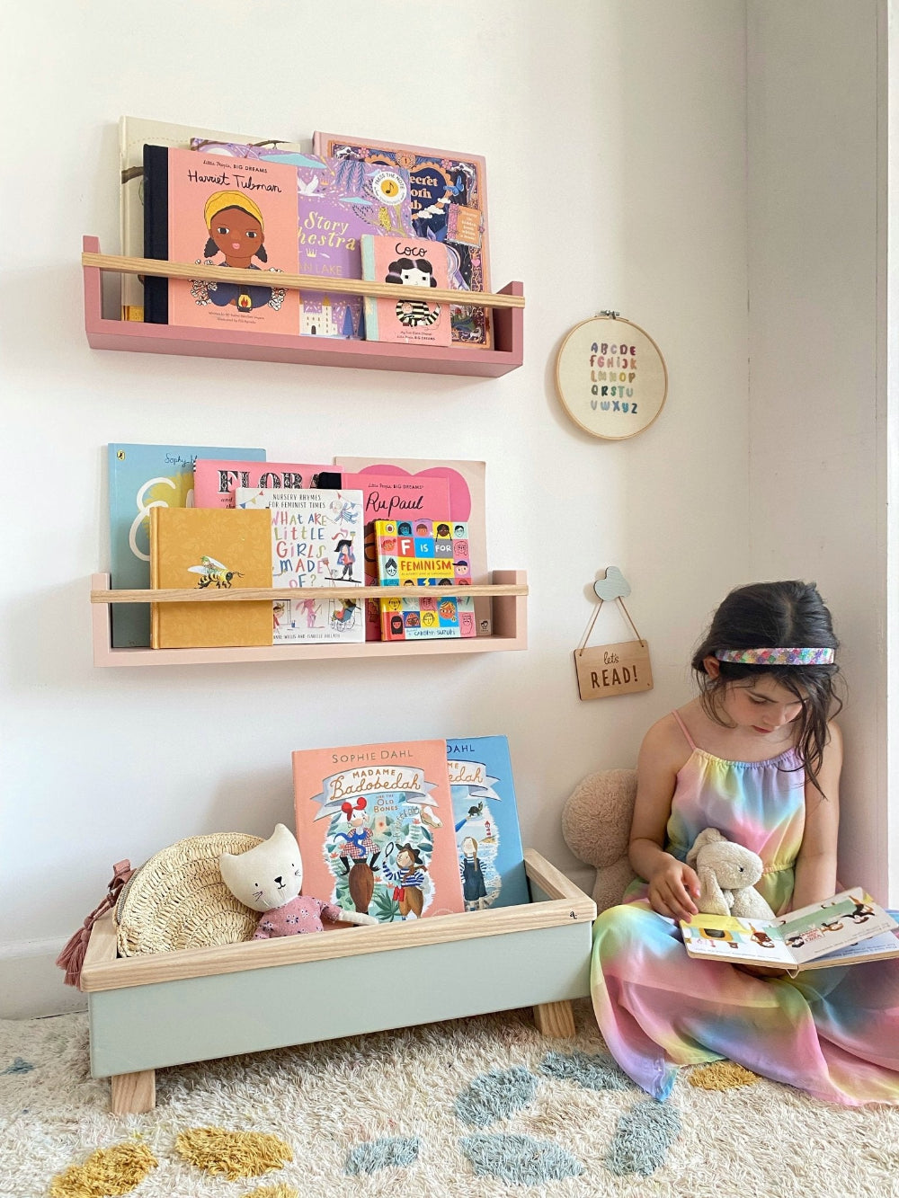 Child reading a book in a room with colorful shelves and toys.