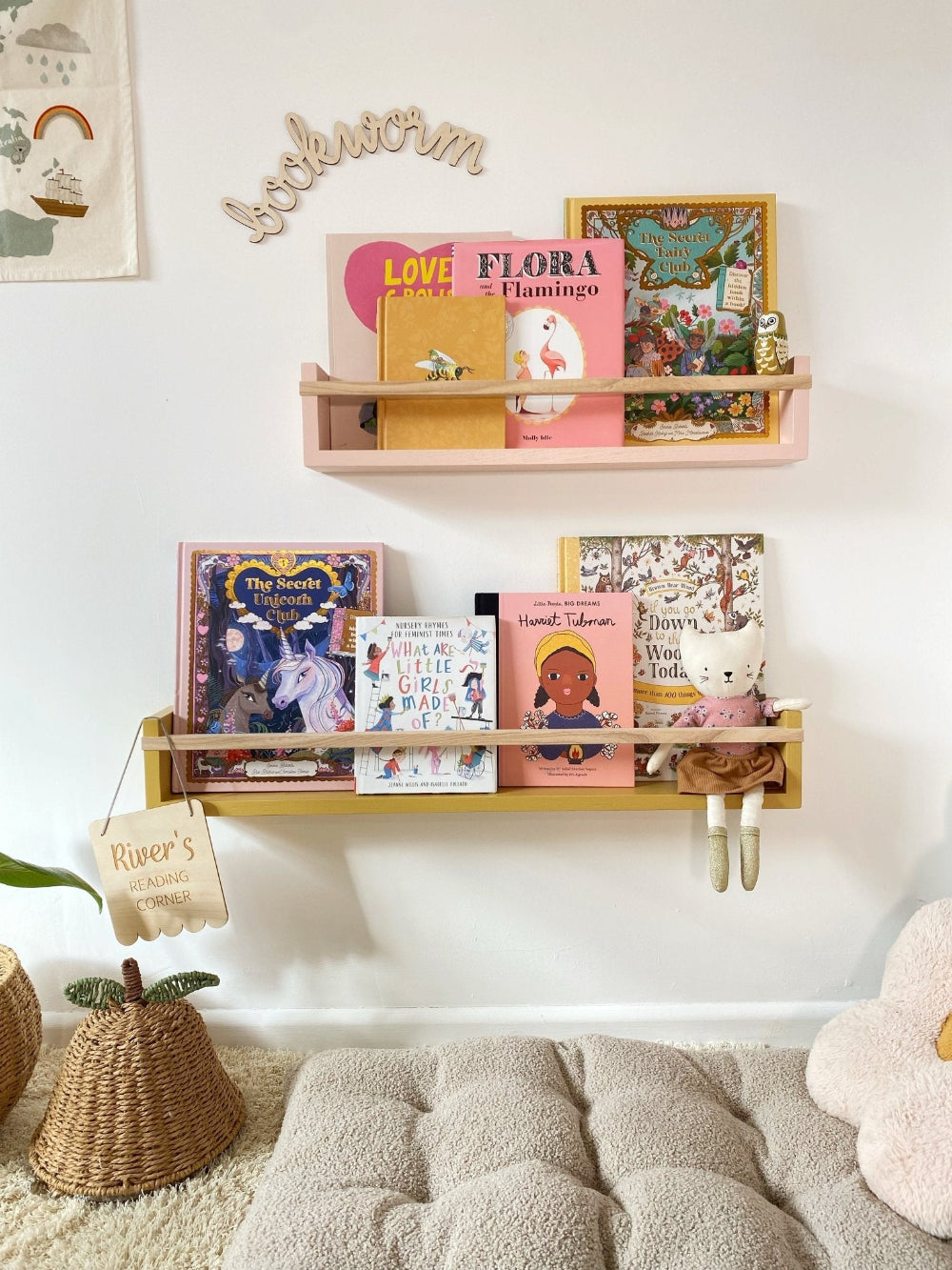 Children's bookshelves with books and decorative items against a white wall.