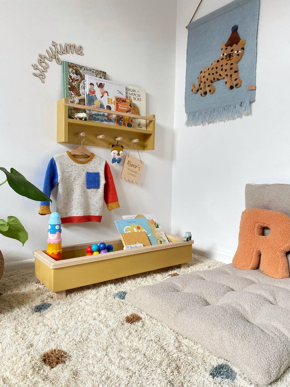 Children's playroom with a shelf, books, and toys on a carpeted floor.
