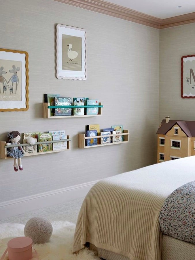 Children's room with shelves, toys, and wall art on a light gray wall.