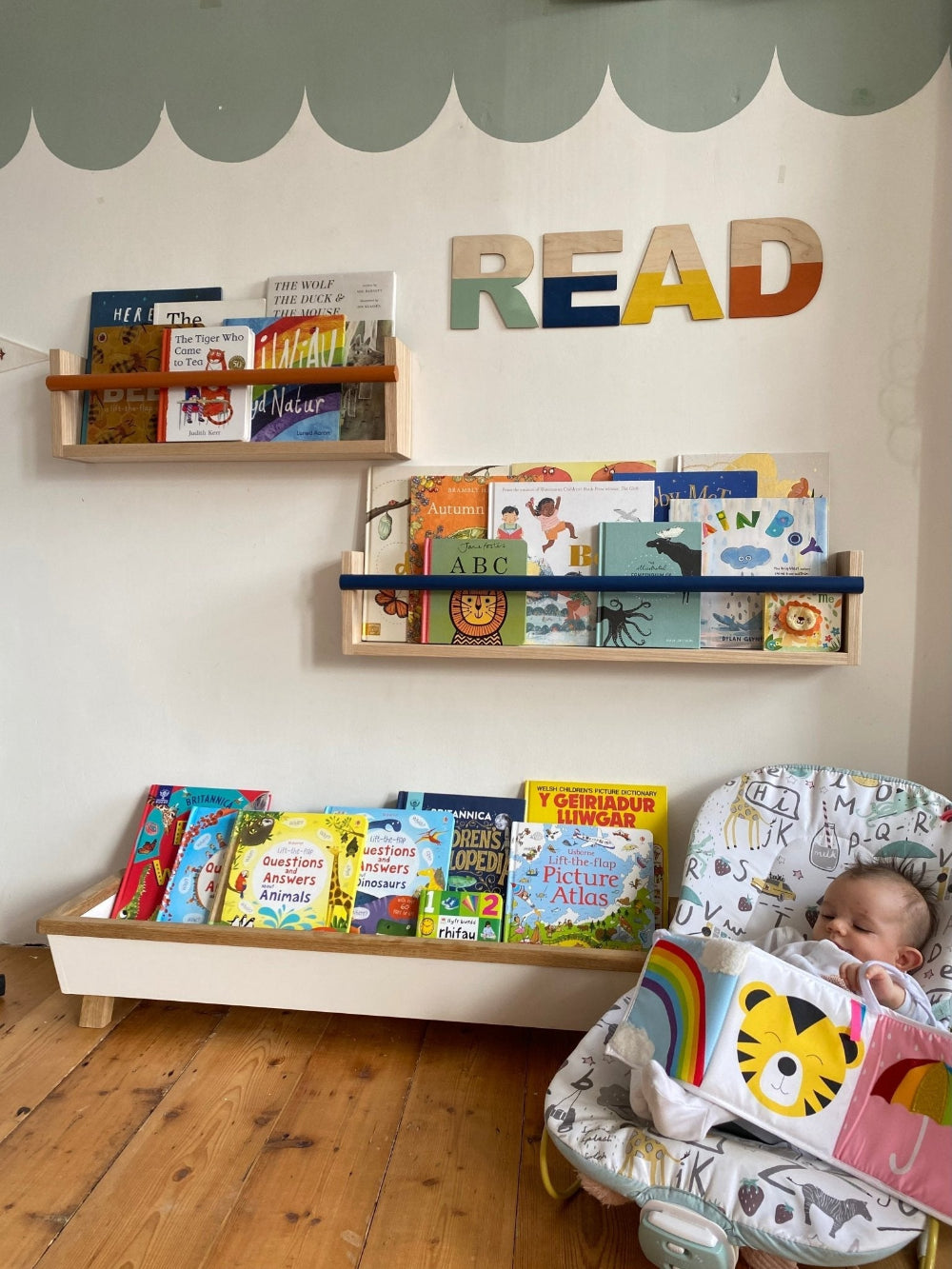 Children's room with bookshelves, books, and a baby in a crib.