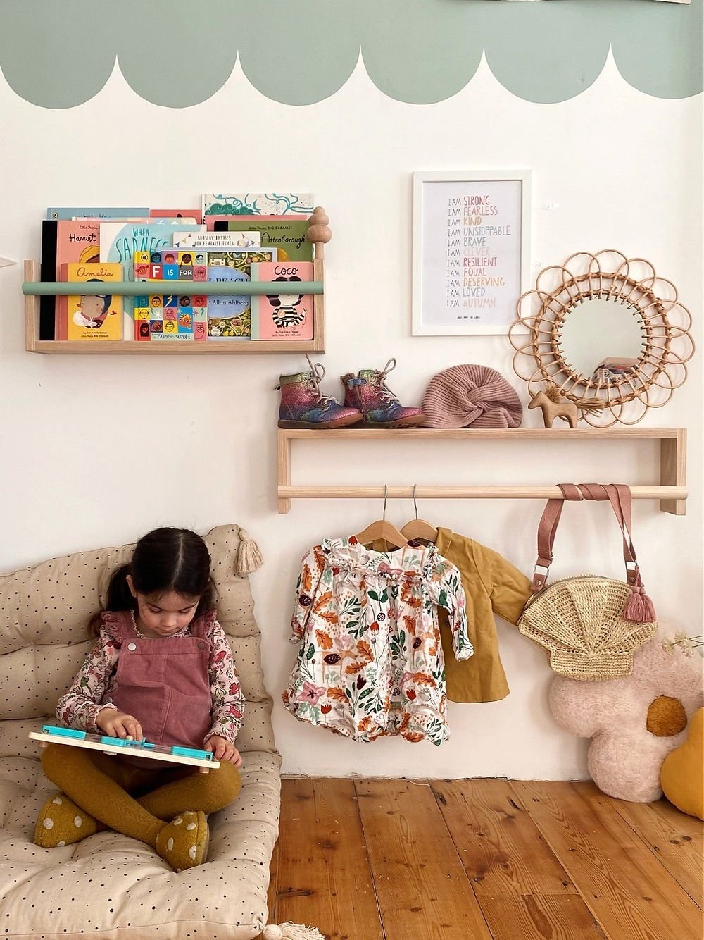 Child reading a book on a couch in a playroom with shelves and toys.
