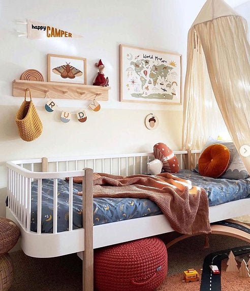 Children's bedroom with a white crib, wooden shelf, and decorative elements.