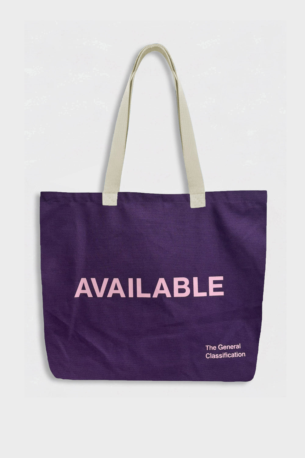 A purple canvas tote bag with light beige shoulder straps and pink text reading 'AVAILABLE' on the front, with smaller white text 'The General Classification' near the bottom right, shown against a light grey background.