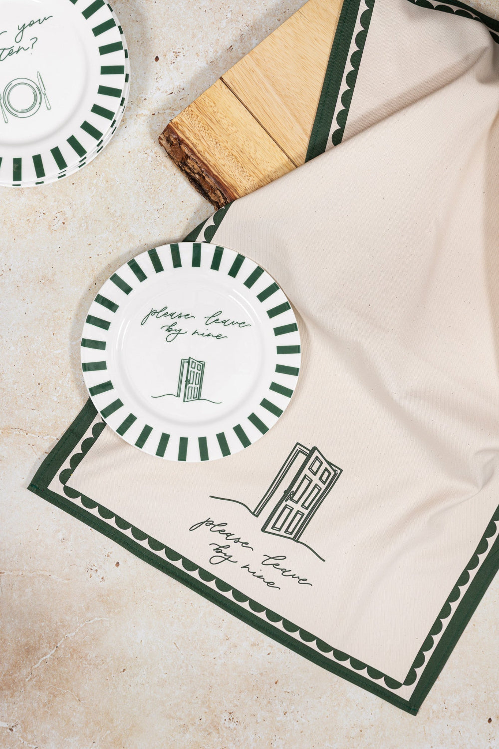 Decorative plates with green and white design on a matching tea towel