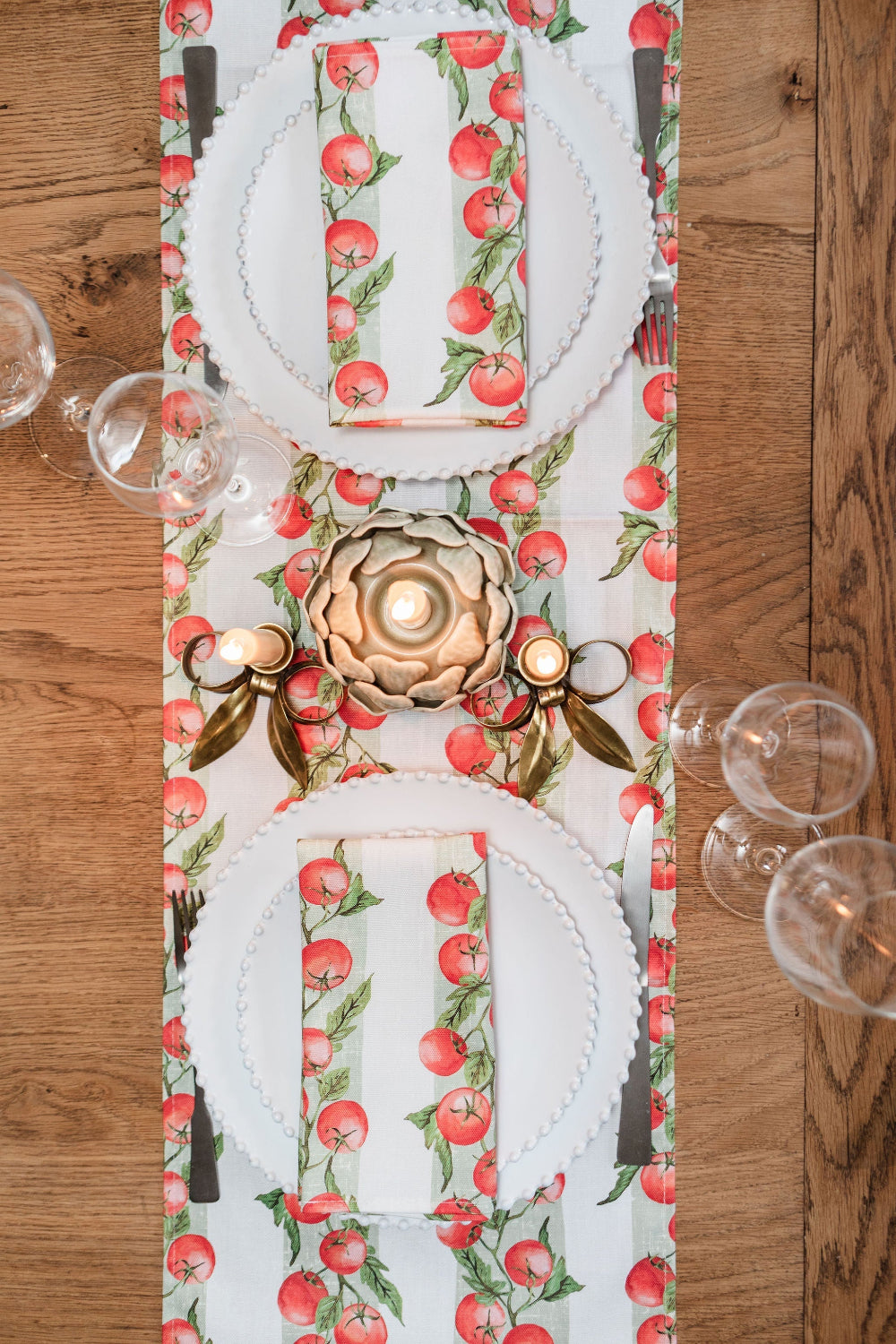 Decorative table runner with tomato pattern on a wooden table