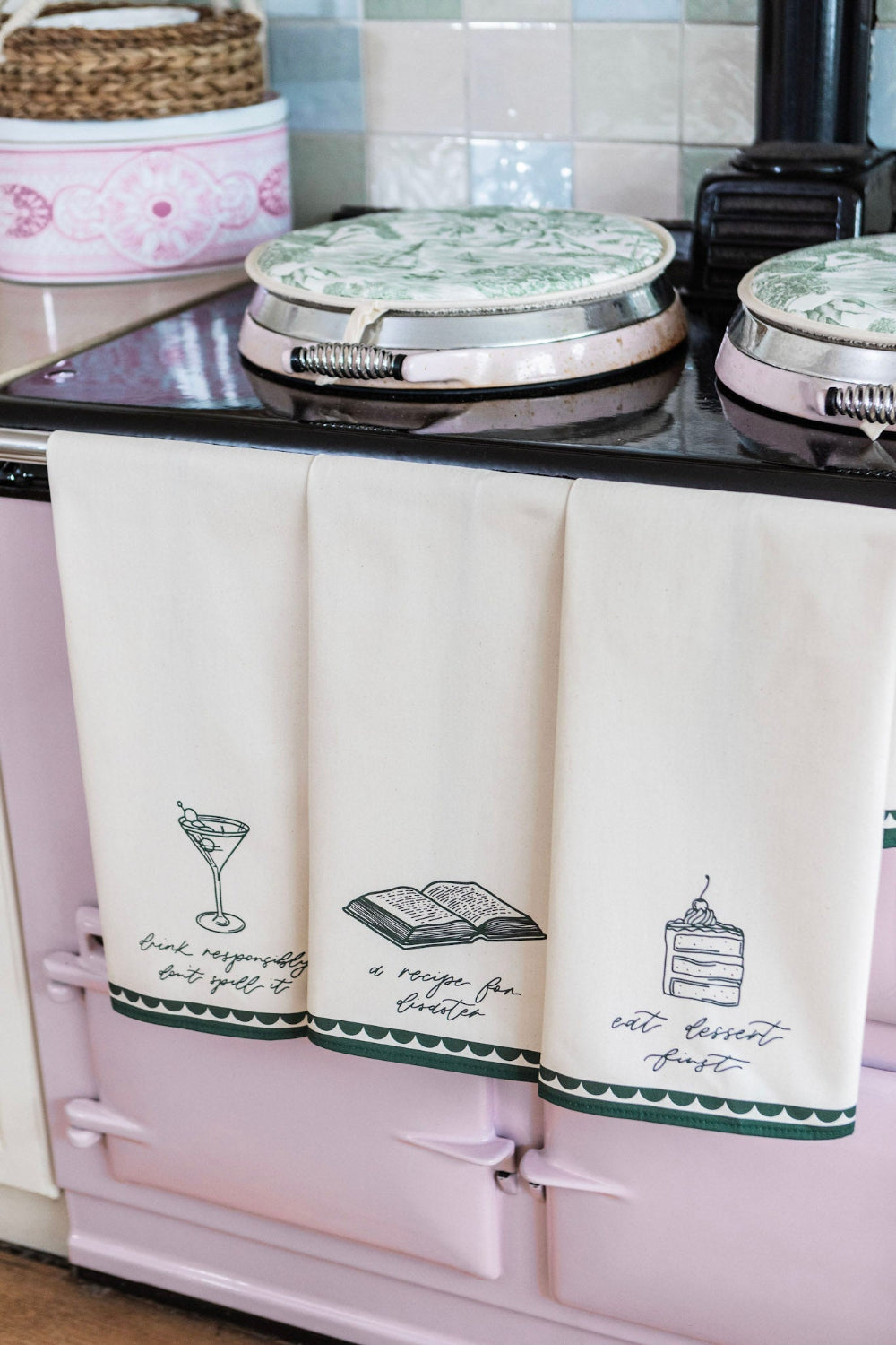 Pink kitchen stove with white towels featuring black text and graphics