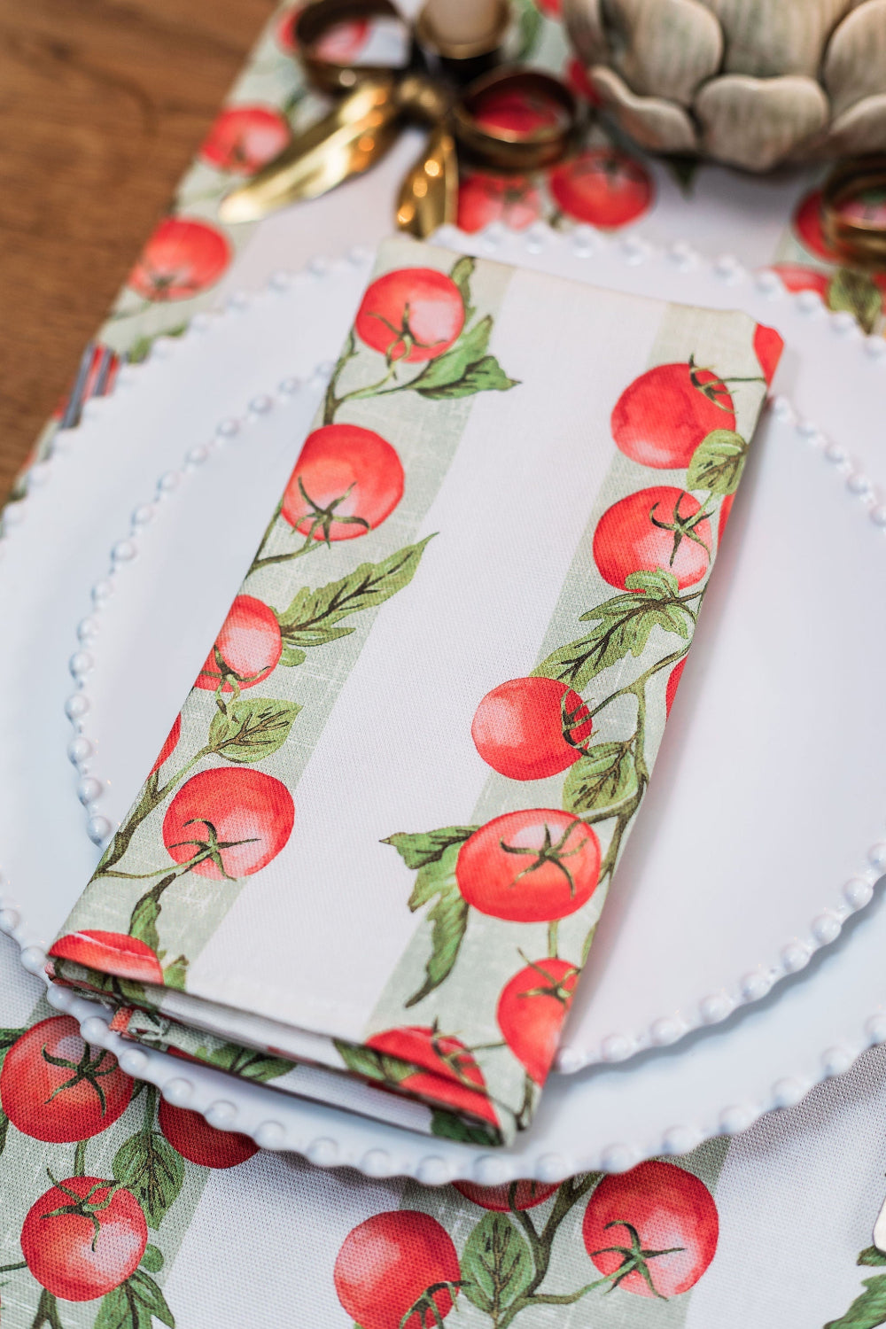 Folded napkin with red tomato pattern on a decorative surface