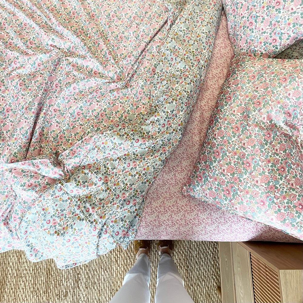 Floral fabric with a person standing underneath it on a carpeted floor.
