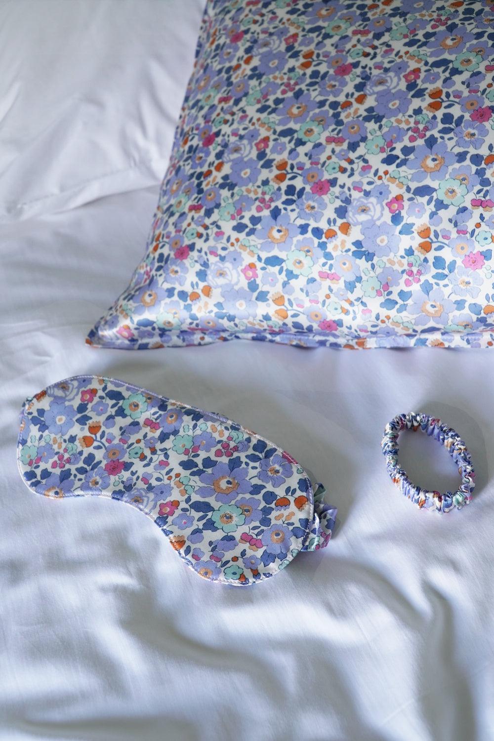 Liberty Floral-patterned eye mask and scrunchie on a white fabric background