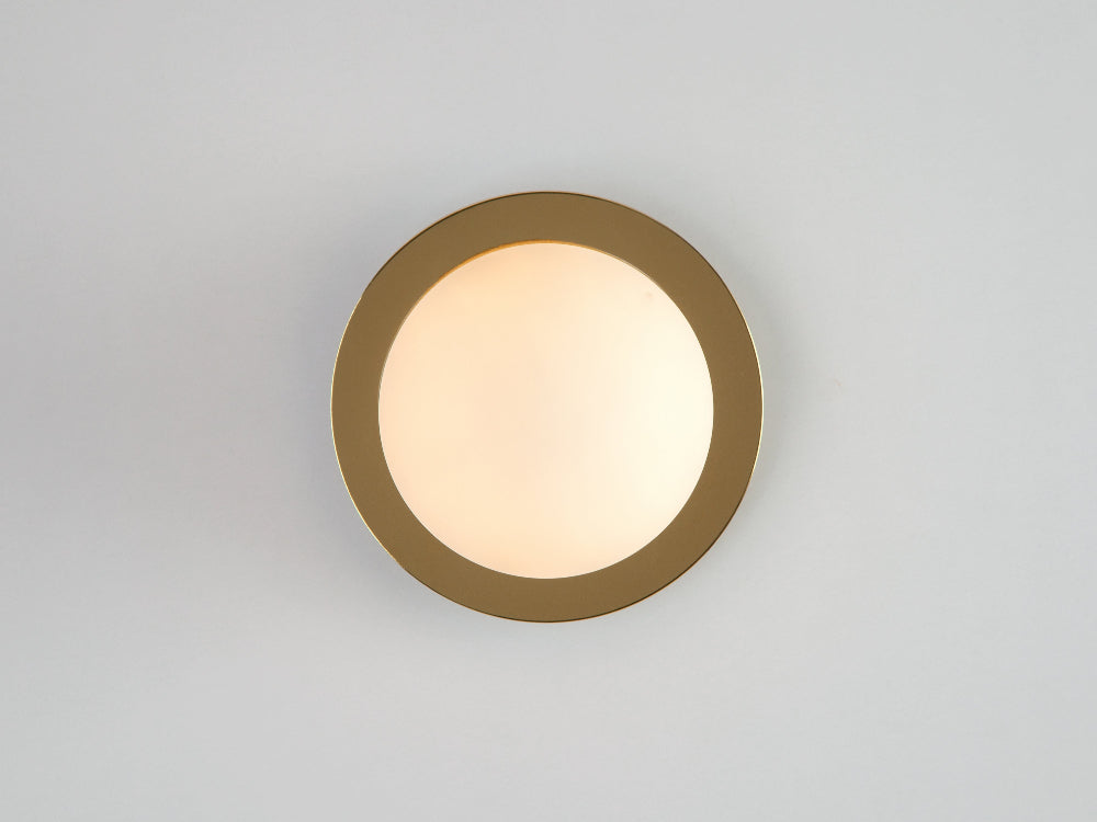 Brass opal disk wall light with polished brass base and opal glass shade