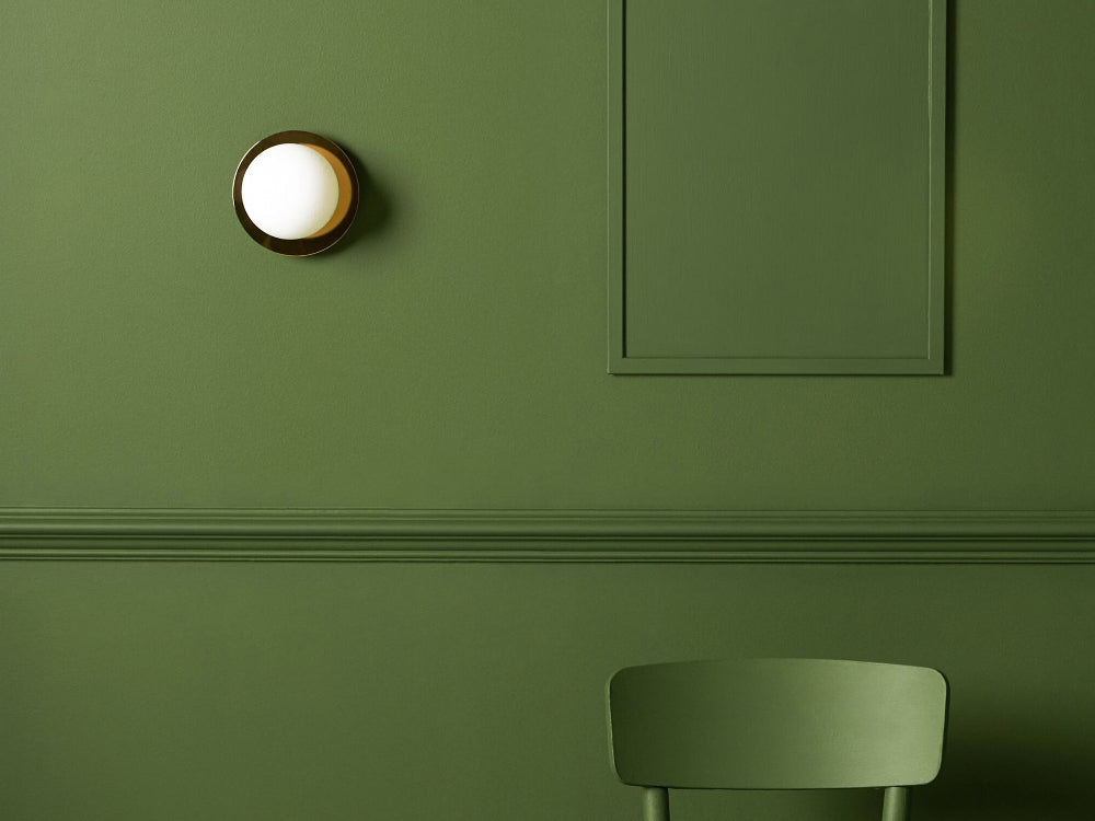 Brass opal disk wall light mounted on an interior wall