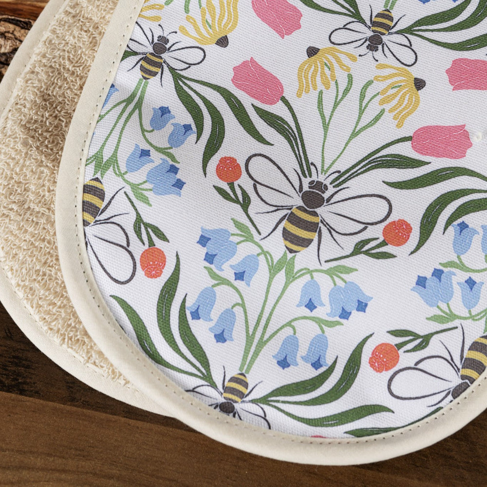 Oven mitt with floral and bee pattern on a wooden surface