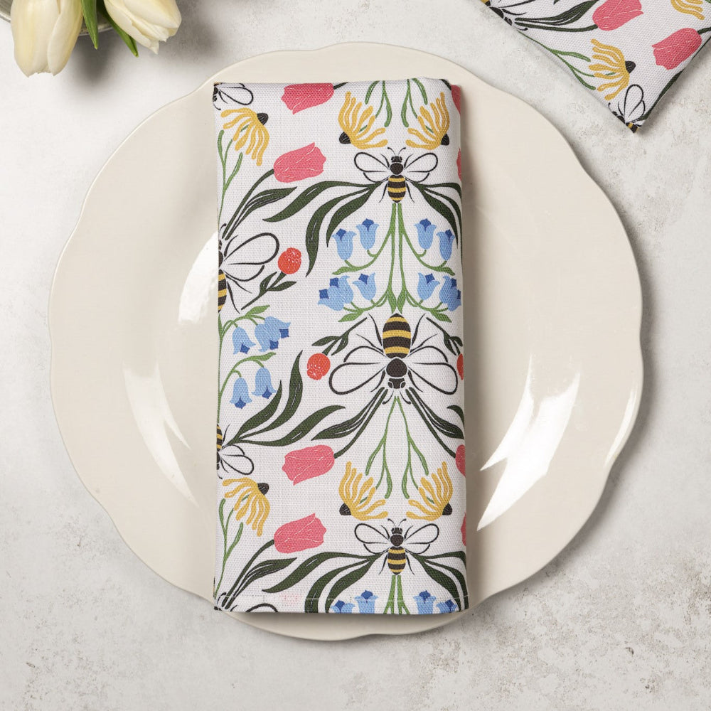 Napkin with floral and bee pattern on a white plate
