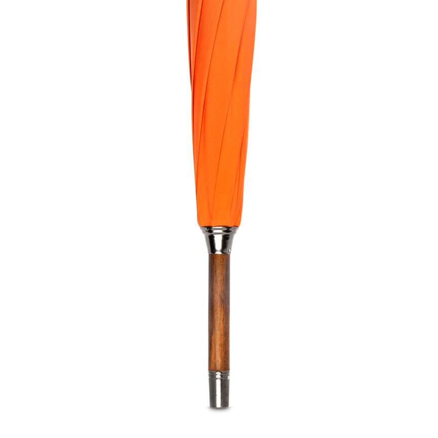 Orange umbrella with wooden handle and silver ferrule on a white background