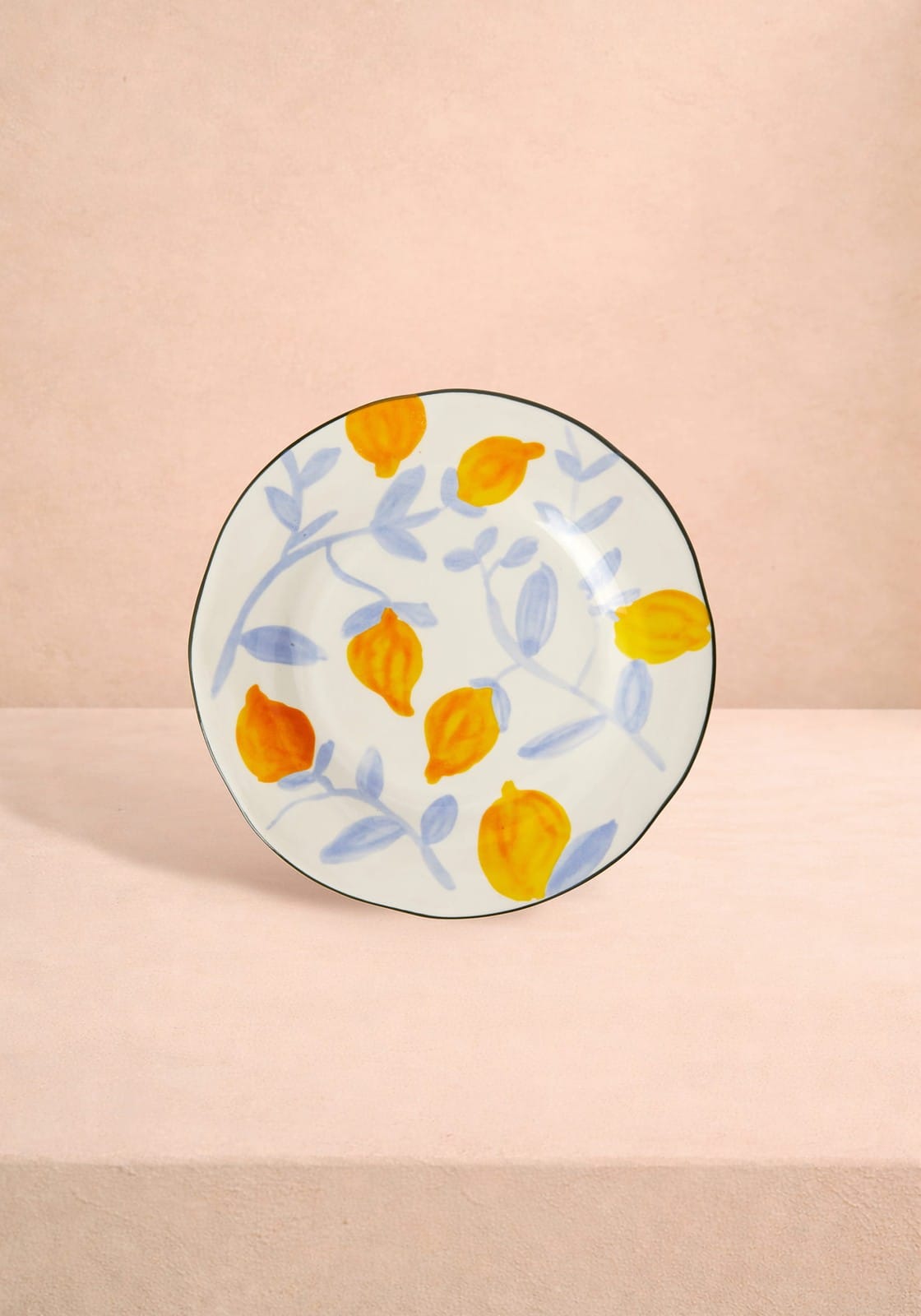 Decorative plate with orange and yellow floral pattern on a beige background